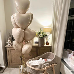 Adorely baby shower decor with cream heart balloons.