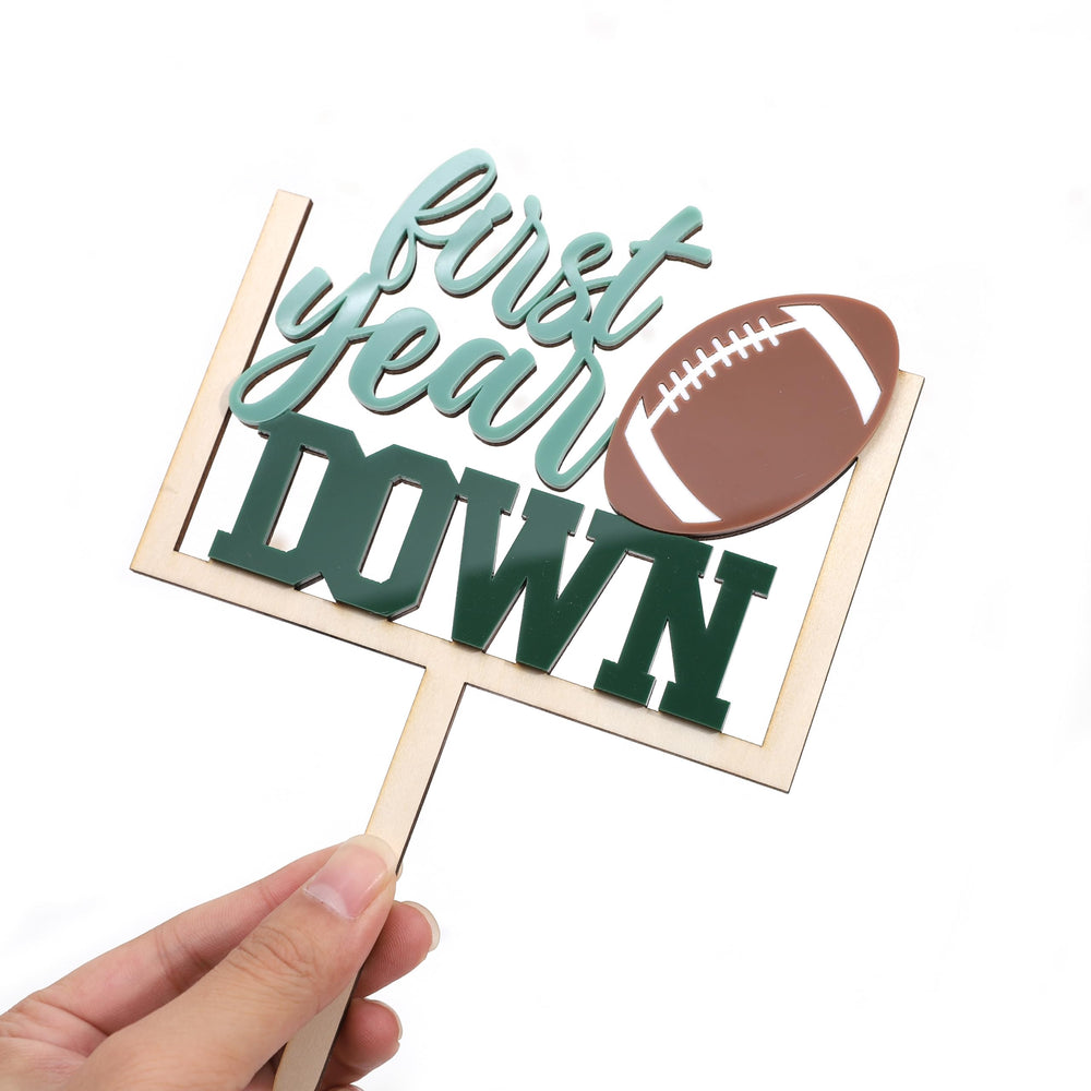 AOQURE football cake topper used as a photo prop in a party setting