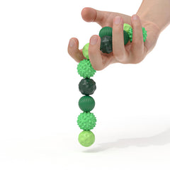 Hands manipulating AotBlcer magnetic balls demonstrate spinning and bouncing modes.