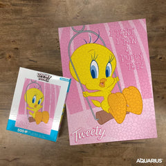 Hands assembling Aquarius Tweety puzzle, highlighting shared activity and fun.