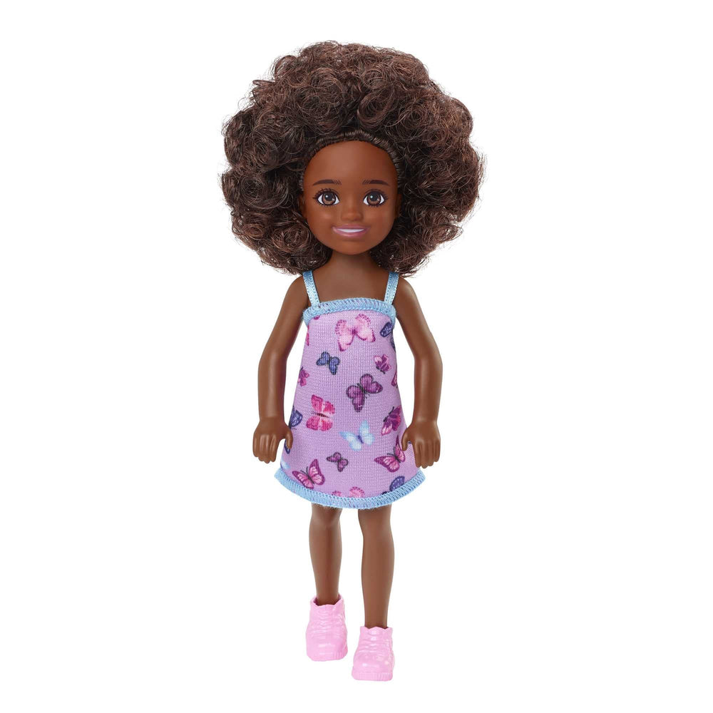 Barbie Chelsea doll with curly brunette hair wearing butterfly dress and pink shoes for imaginative play.