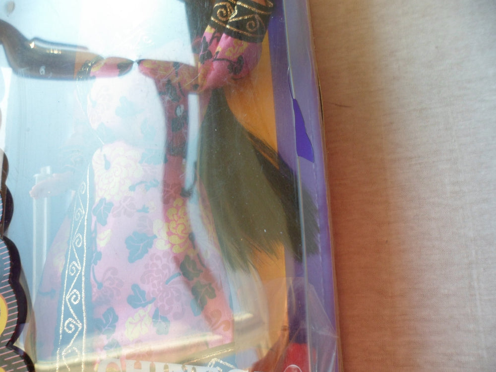 Chinese attire details showing black and gold border on Barbie's outfit.