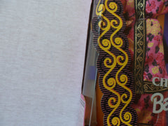 Barbie in chrysanthemum print guazi robe close-up highlighting vibrant pattern.