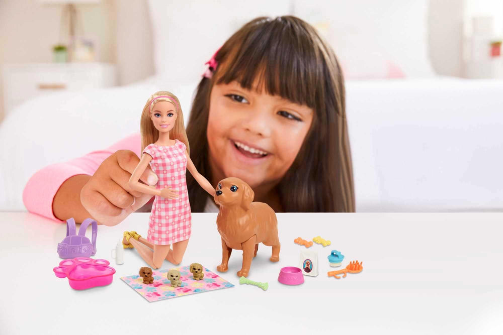 Barbie presses mom dog's back to reveal a puppy.