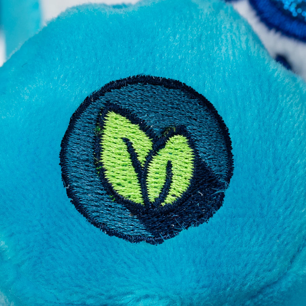 Care Bears Glitter belly badge close-up showing sparkle on Grumpy Bear.