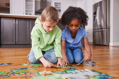 Crocodile Creek puzzle pieces arranged on the floor for playtime.