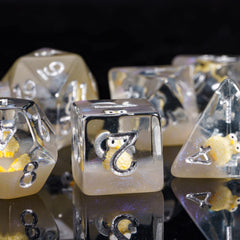 Close-up of owl-filled glitter dice highlighting readable silver numerals.