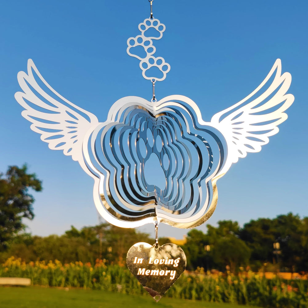 DJUAN pet memorial wind spinner with angel wings reflecting sunlight.