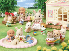 Epoch Sylvanian Silk Cat Baby displayed on a dollhouse shelf