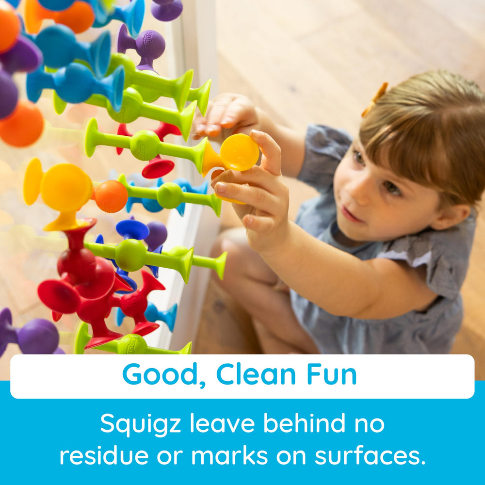 Fat Brain Toys Squigz colorful pieces on tub edge inviting exploration.