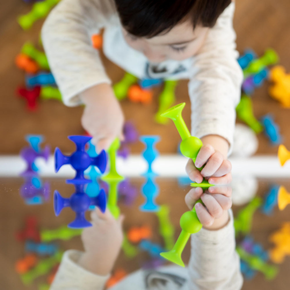 Fat Brain Toys Squigz create suction shapes on bathroom tiles.
