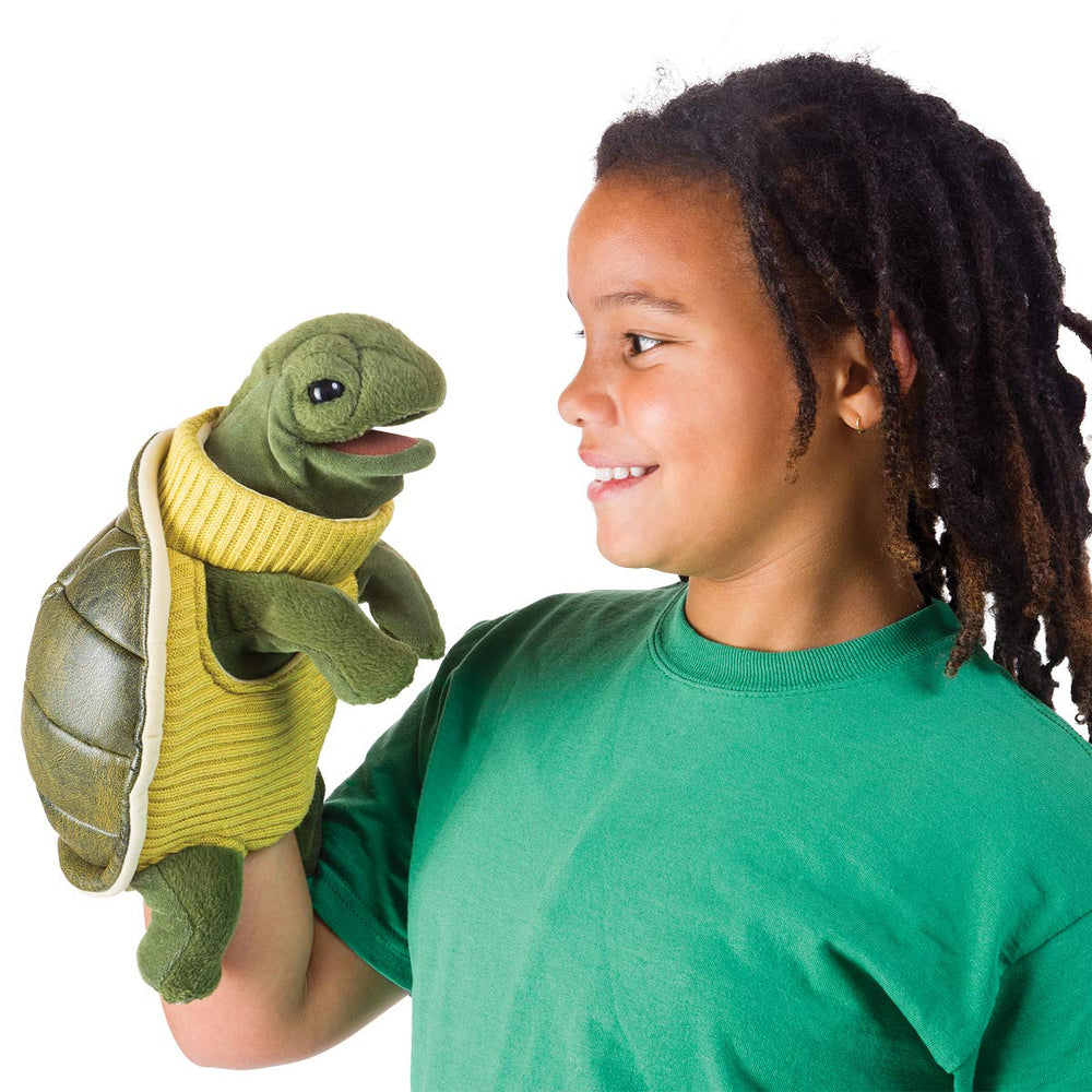 Folkmanis Turtleneck Turtle hand puppet on stage, ideal for lively pretend play.