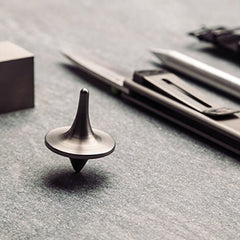 ForeverSpin titanium top resting on wood surface showcasing premium craftsmanship