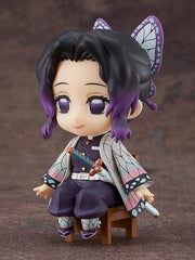 Good Smile Demon Slayer Shinobu Kocho Swacchao chair-edge display on a compact desk.