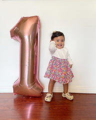 IWERP first birthday rose gold balloon setup creates a playful focal point.