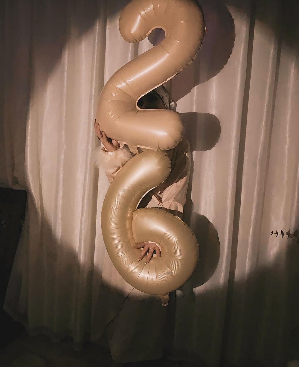 IWERP light brown number 6 balloon in a birthday backdrop for milestone moments