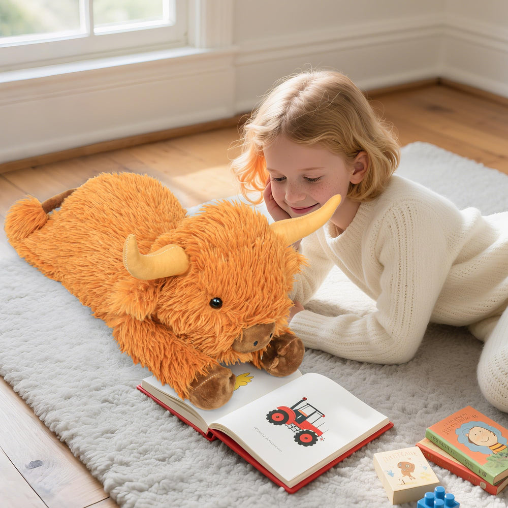 JellyMallow Highland Cow plush on a couch, serving as decor and cuddle buddy.
