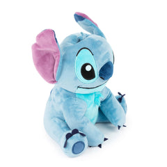 Child hands placing coins into the plush Lilo & Stitch bank.