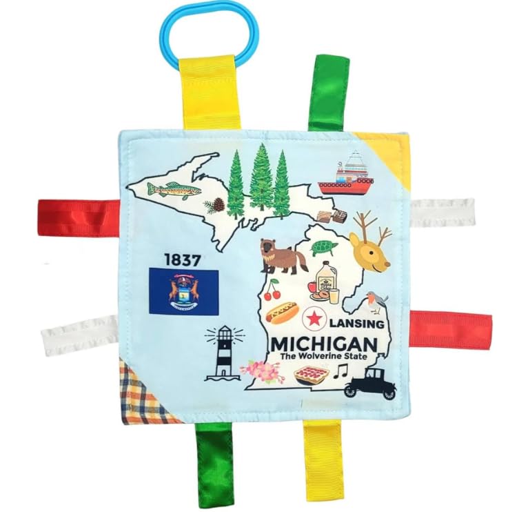 The Learning Lovey Michigan State Tag Toy attached to a stroller for on-the-go exploration