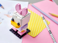 Daisy Duck BrickHeadz on display, ready to brighten a desk or shelf.