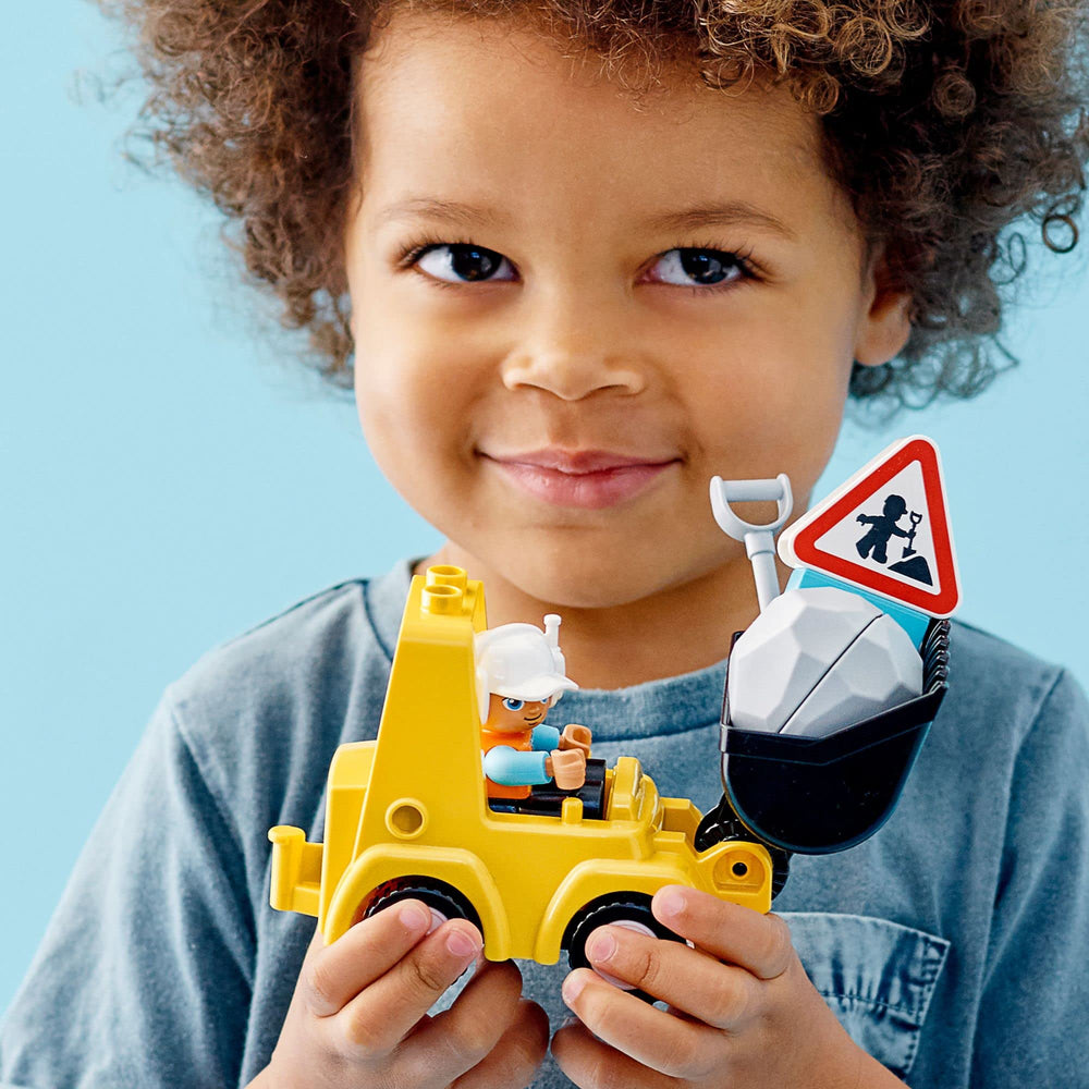LEGO DUPLO bulldozer side view with sign promoting safe construction play.