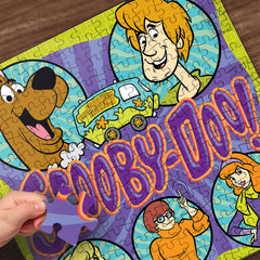 MasterPieces Scooby-Doo puzzle pieces spread on a table inviting collaboration