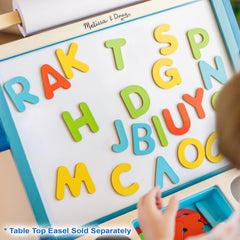 Learning through play with magnetic letters on a family table.