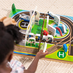 Melissa & Doug wooden truck driving along the runway beside planes.