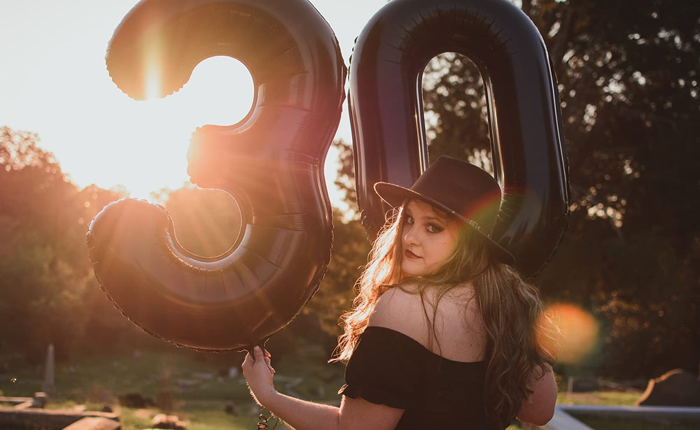 Mluchee number 0 balloon on wall creates a dramatic backdrop for photos.