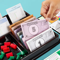 Monopoly money and title deeds organized for fast reference during turns.