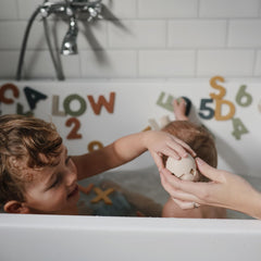 Mushie five-piece dino set designed for sensory exploration during bath time
