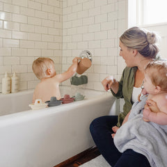 Mushie Petal boats assembled into a floating train for toddlers.