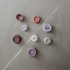 Mushie Stacking Cups Petal in baby's hands supports grasp development during early play.