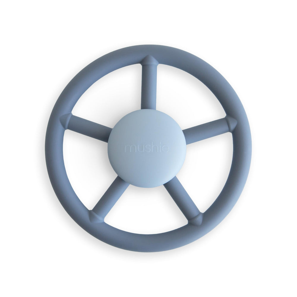 Mushie Wheel suction spinner toy on bath surface for sensory play.