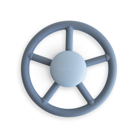 Mushie Wheel suction spinner toy on bath surface for sensory play.