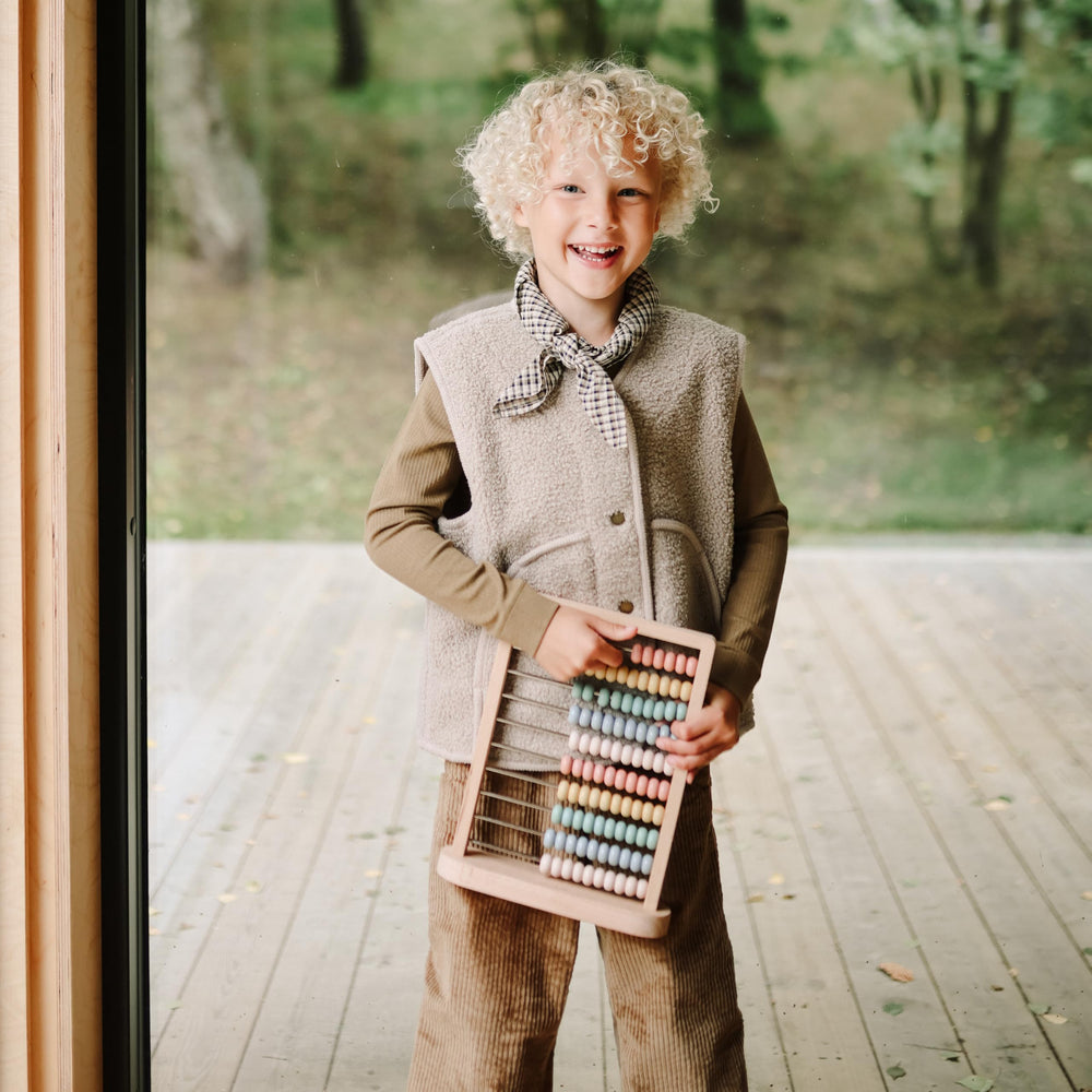 Mushie wooden abacus in a nursery setting to inspire timeless play