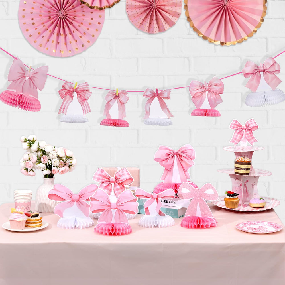 NatNarr pink bow honeycomb centerpiece creates a playful dessert table focal point.