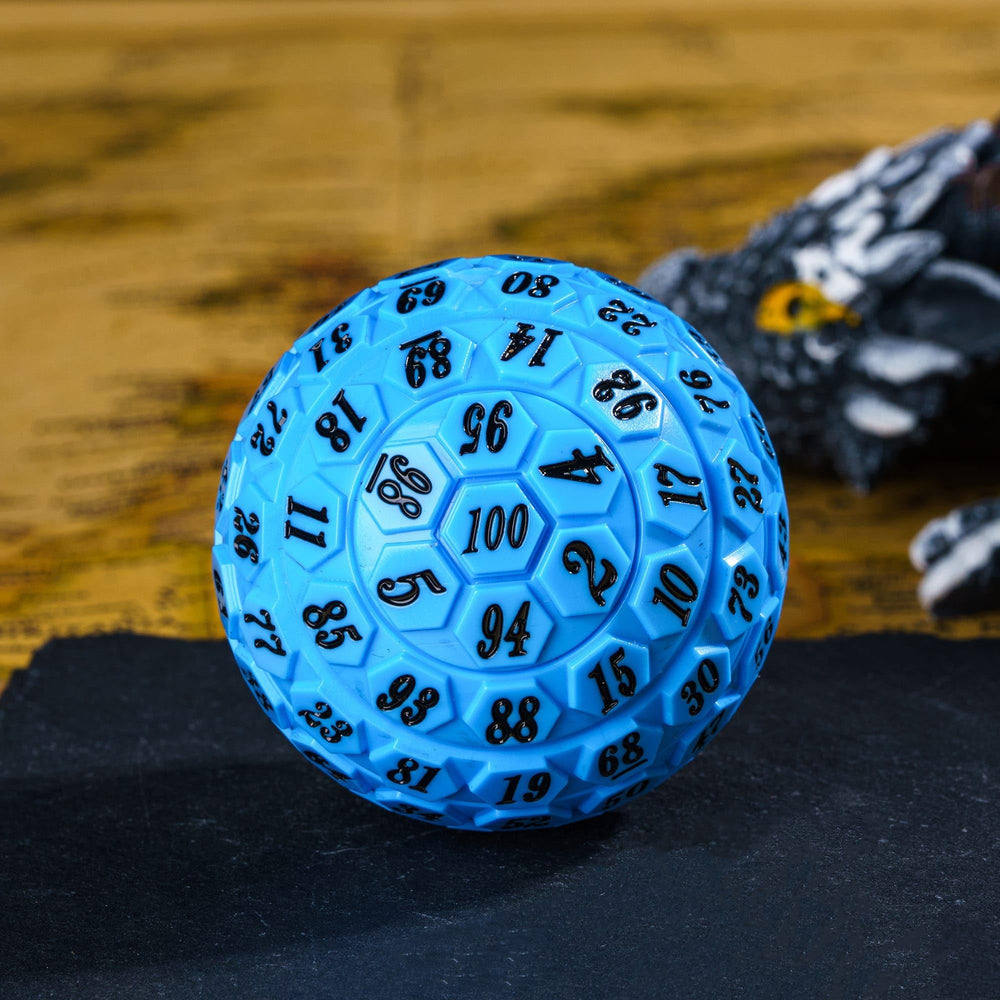 Poludie blue 100‑sided die beside a sci‑fi board game.