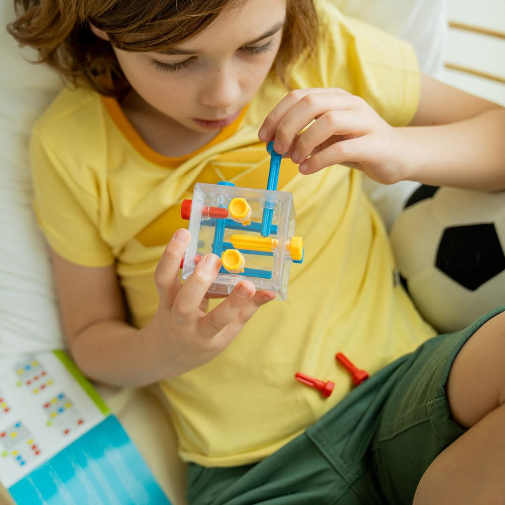 SmartGames Criss Cross Cube pieces laid out for hands-on problem solving.