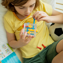 SmartGames Criss Cross Cube pieces laid out for hands-on problem solving.