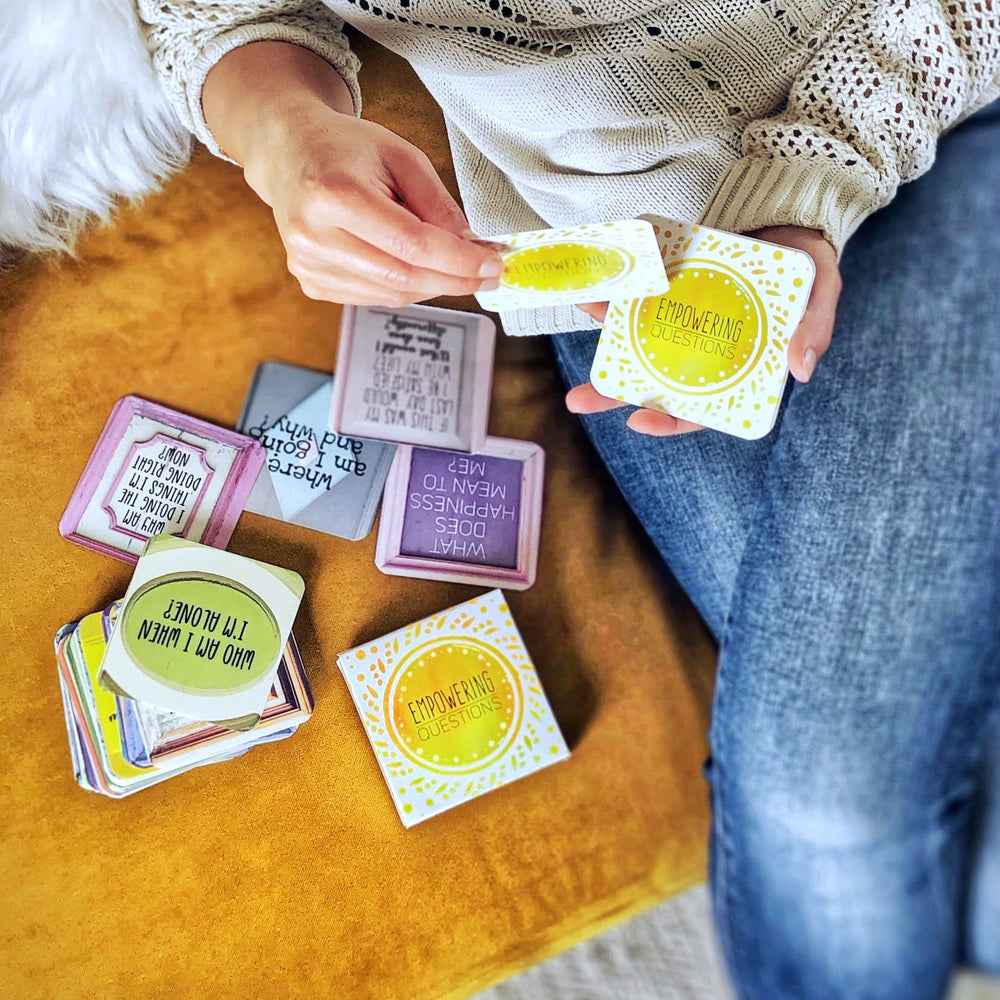 Sunny Present Empowering Questions Cards laid out beside a notebook.