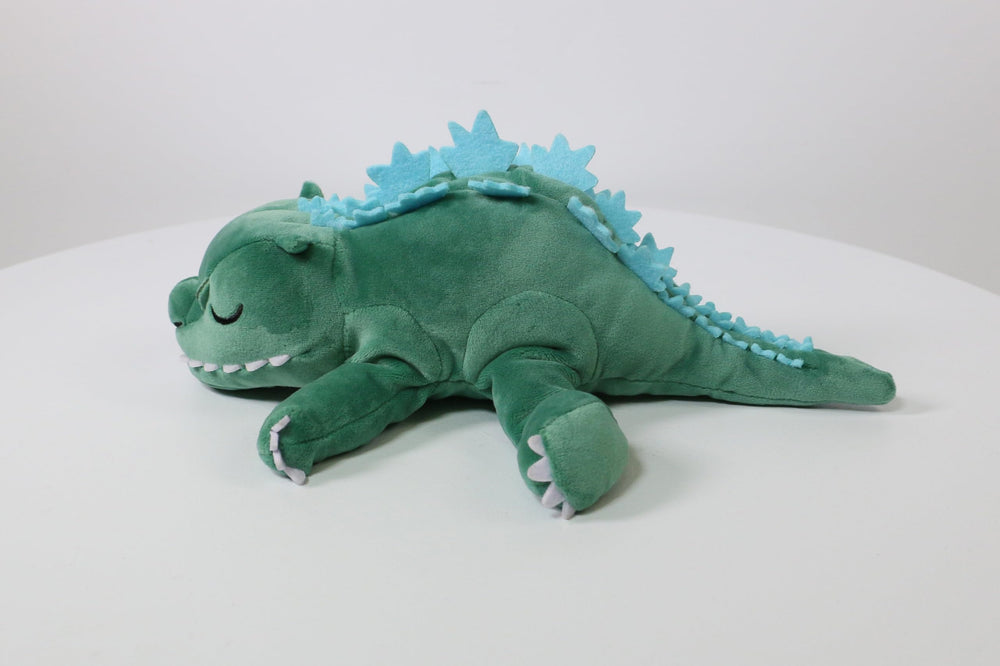 Side profile view of Surreal Entertainment Godzilla sleeping plush on display.