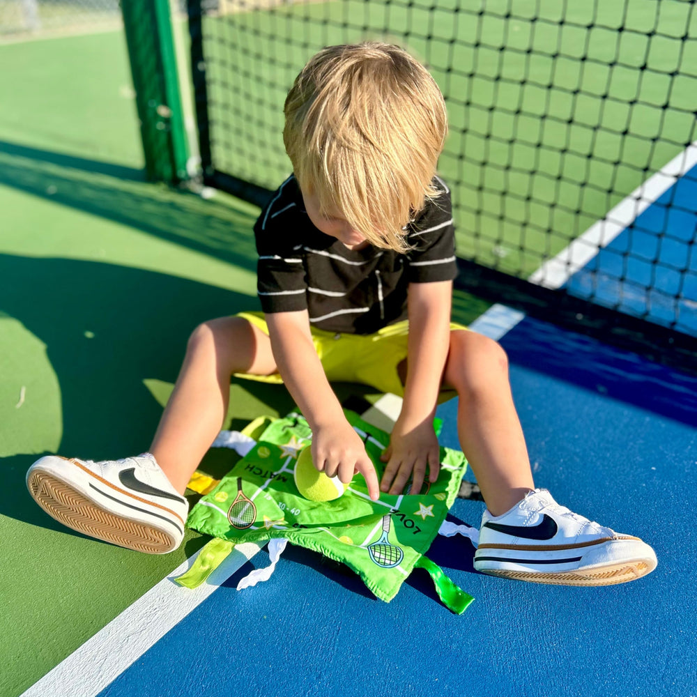 The Learning Lovey tennis sensory lovey with stroller clip for easy attachment.