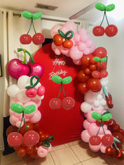 TiAaihion party centerpiece with cherry balloons enhances table decor.