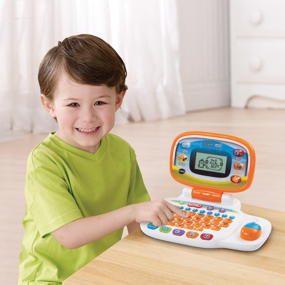 Child uses the orange VTech laptop for hands-on learning on the go.