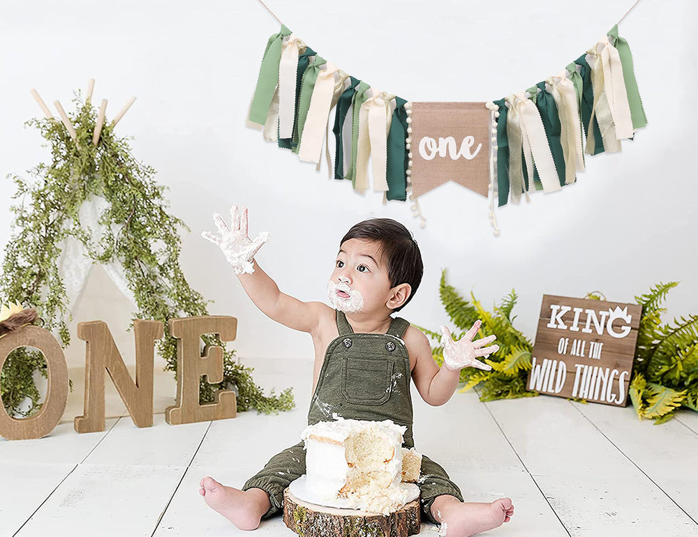 WAUAO Wild One highchair banner draped on chair for photos.