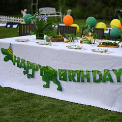 WERNNSAI green dinosaur banner adds whimsical focal point to celebration.