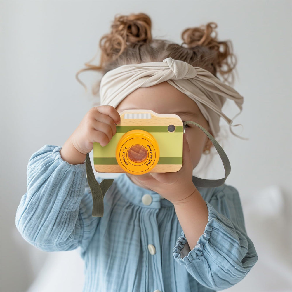 WoodenEdu wooden mini camera held by a toddler showcases portable educational toy benefits.