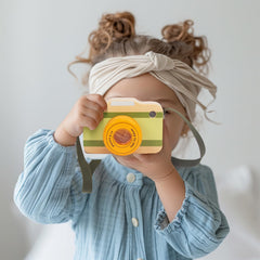 WoodenEdu wooden mini camera held by a toddler showcases portable educational toy benefits.