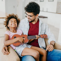 YEZI Kids ukulele brown family playtime scene, encourages shared music.